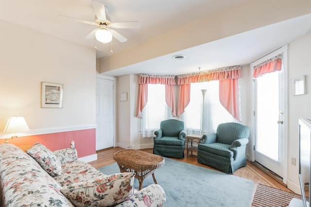 living room featuring ceiling fan, plenty of natural light, and light hardwood / wood-style floors