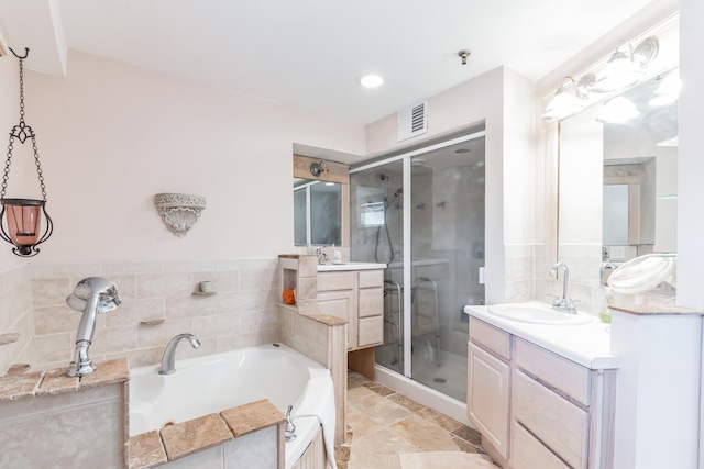 bathroom with vanity and independent shower and bath