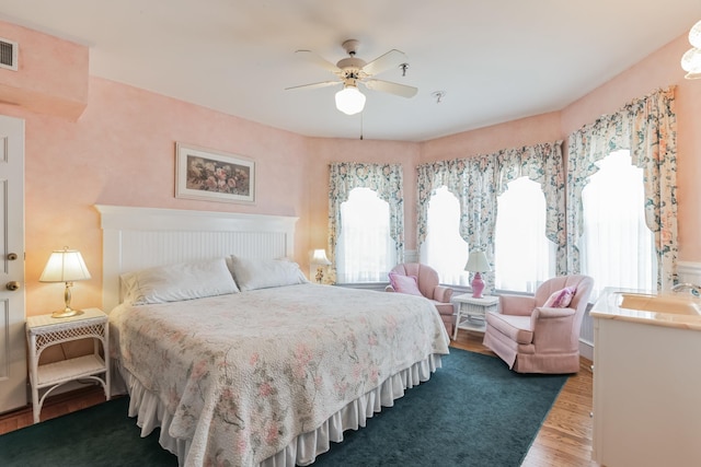 bedroom featuring ceiling fan, wood-type flooring, and sink