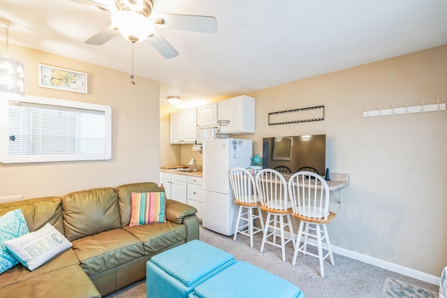 carpeted living room with ceiling fan and sink