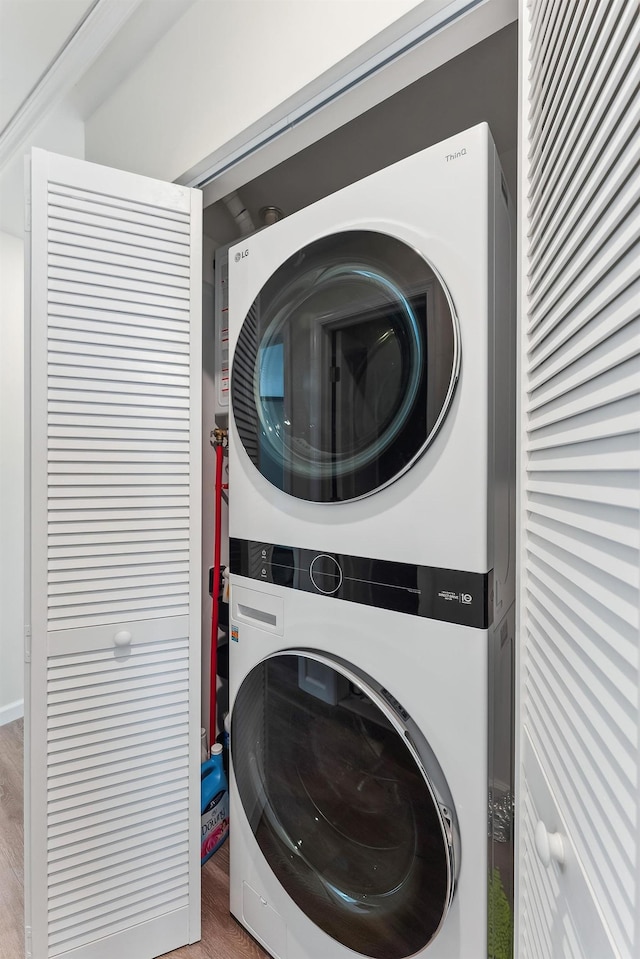 washroom with stacked washing maching and dryer and laundry area