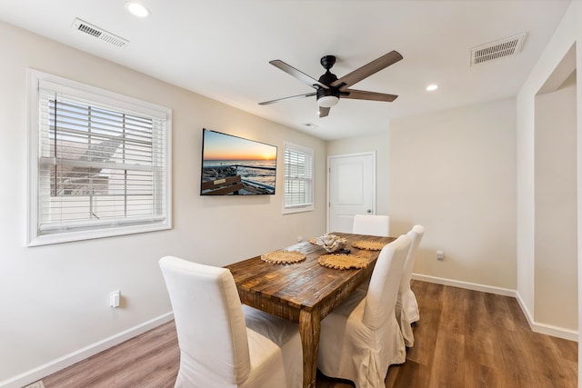dining room featuring baseboards, ceiling fan, visible vents, and wood finished floors
