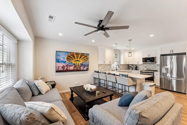 living area with visible vents, light wood-style flooring, and a healthy amount of sunlight