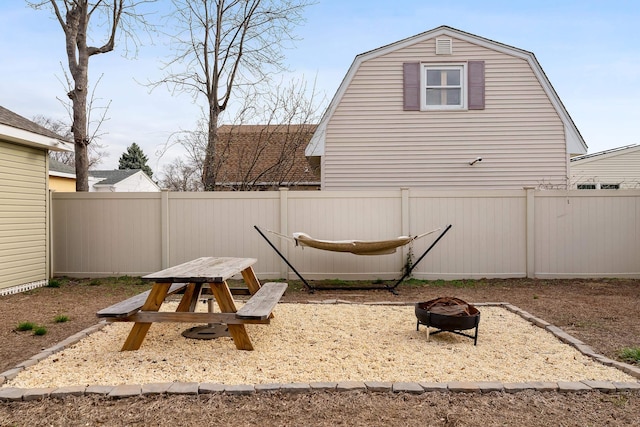 view of playground featuring a fenced backyard and a fire pit