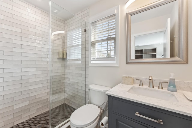 bathroom with toilet, a stall shower, and vanity