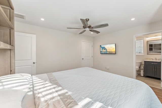 bedroom featuring light wood-type flooring, recessed lighting, a sink, and visible vents