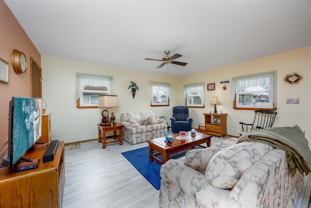 living room featuring light hardwood / wood-style flooring, ceiling fan, and a healthy amount of sunlight