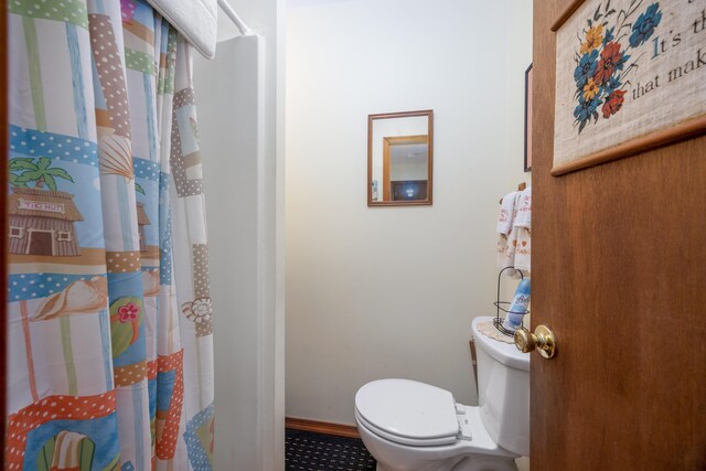 bathroom with a shower with curtain and toilet