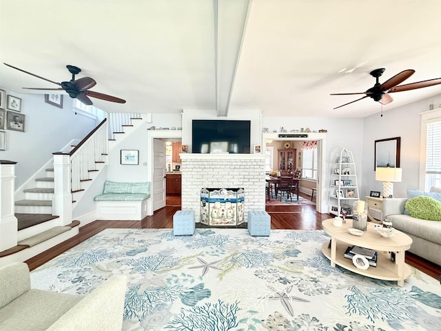 168 98th St, Stone Harbor, NJ 08247 - living room featuring a brick fireplace, dark wood finished floors, ceiling fan, and stairway