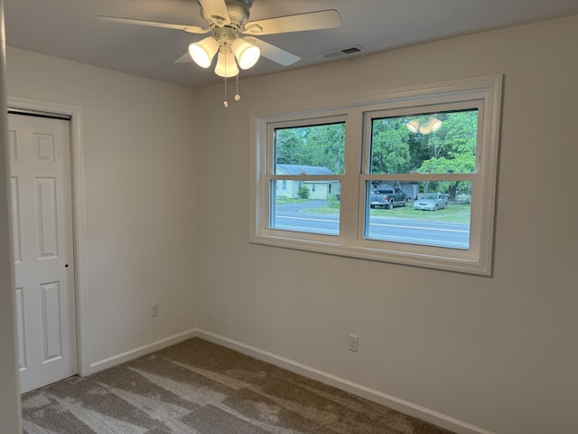 unfurnished room featuring baseboards, carpet floors, and a ceiling fan