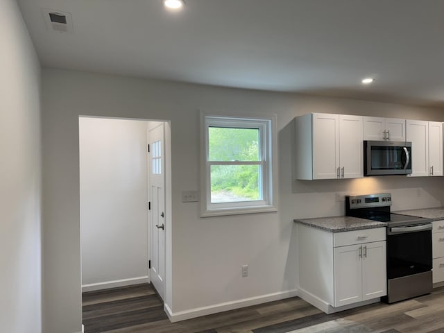 kitchen featuring stainless steel appliances, dark wood-type flooring, recessed lighting, white cabinetry, and baseboards
