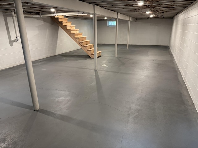 basement with stairs and concrete block wall