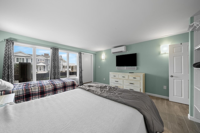 bedroom with hardwood / wood-style flooring and a wall mounted AC