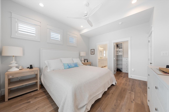 bedroom featuring light hardwood / wood-style flooring, ensuite bath, ceiling fan, a spacious closet, and a closet