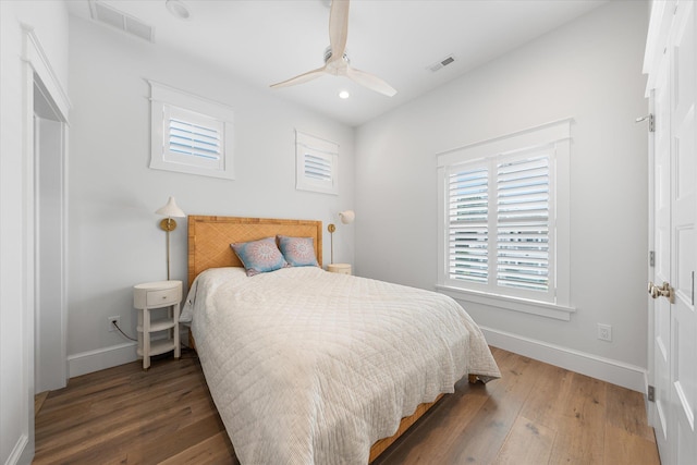 bedroom with dark hardwood / wood-style floors and ceiling fan