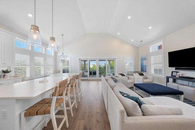 living room featuring light wood-type flooring and high vaulted ceiling