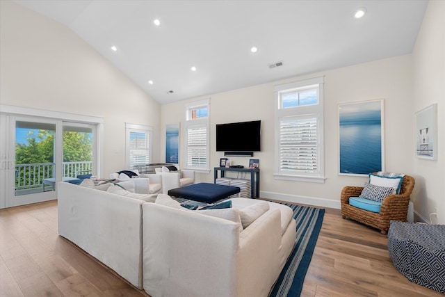 living room featuring light hardwood / wood-style floors and high vaulted ceiling