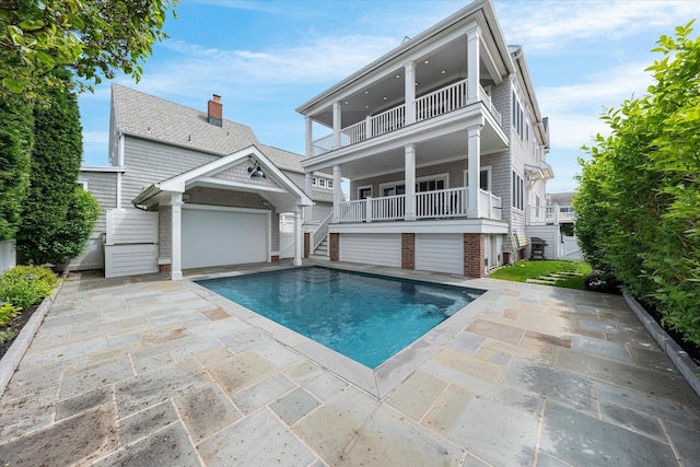 back of property featuring a balcony and a garage