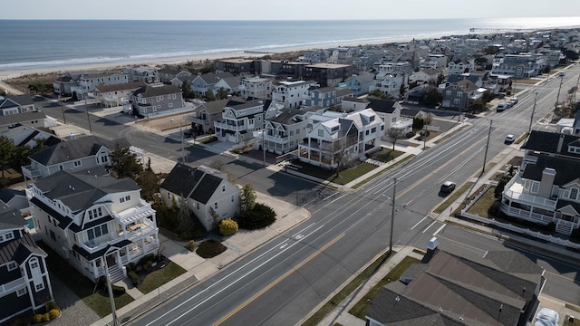 aerial view featuring a view of the beach, a water view, and a residential view