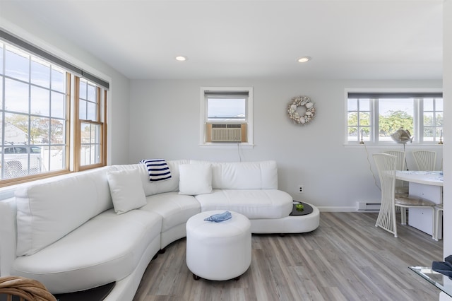 living room featuring light wood-type flooring, plenty of natural light, and cooling unit