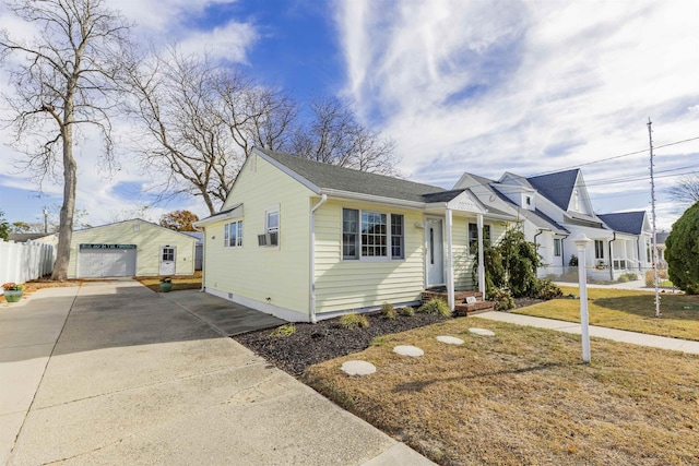 view of front of home featuring a garage, an outbuilding, and a front yard