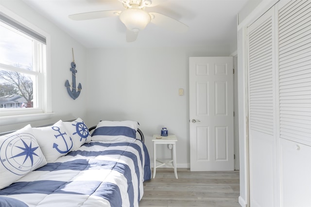 bedroom featuring light wood-type flooring, a closet, and ceiling fan