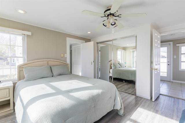 bedroom featuring a closet, light hardwood / wood-style flooring, and ceiling fan