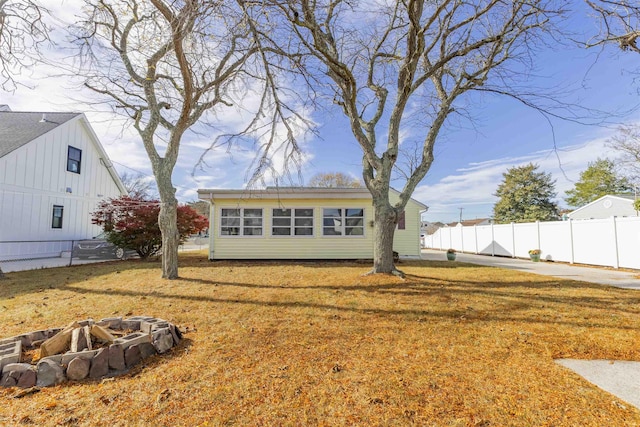 rear view of property with a yard and a fire pit