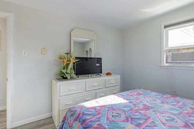 bedroom with light hardwood / wood-style flooring and cooling unit