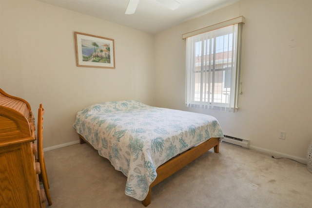 carpeted bedroom with ceiling fan and a baseboard heating unit