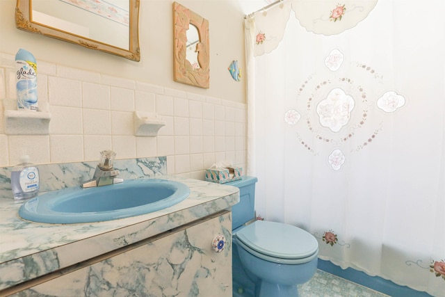 bathroom featuring vanity, tile walls, and toilet