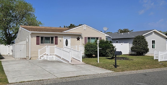 ranch-style home with an outdoor structure, a front lawn, fence, a patio, and a storage unit