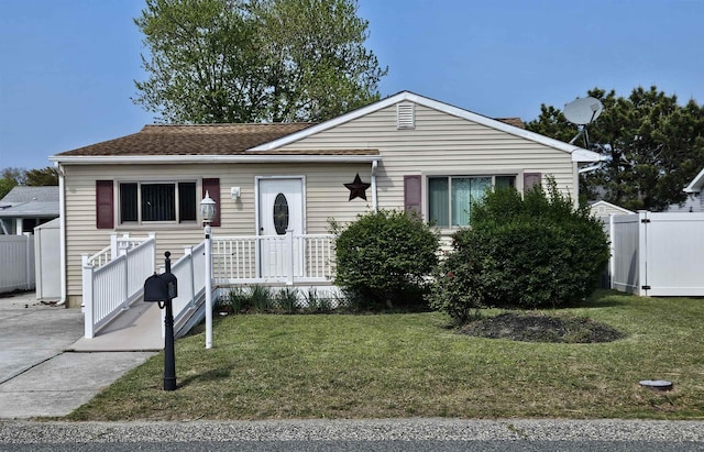 view of front of house with a front lawn and fence