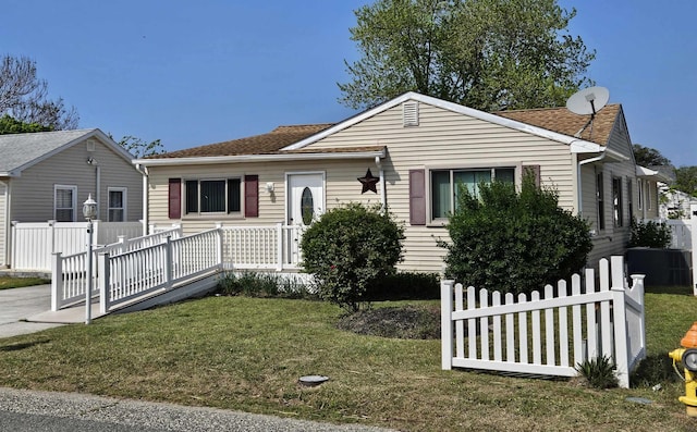 view of front of property with fence, a shingled roof, and a front yard