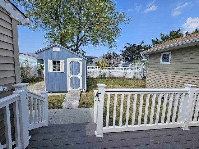 wooden deck with a storage unit, an outdoor structure, a fenced backyard, and a yard