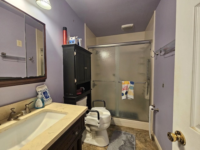 full bath with vanity, baseboards, a stall shower, and toilet