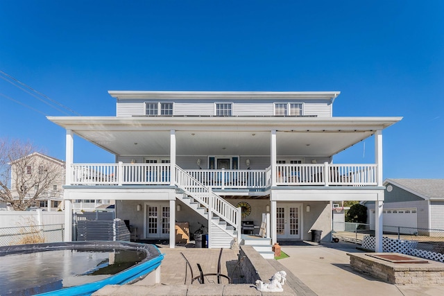 back of house featuring french doors, a patio, stairway, and fence