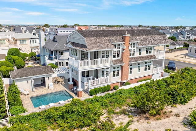 1 108th St, Stone Harbor, NJ 08247 - rear view of property featuring a residential view, a balcony, a fenced backyard, a chimney, and an outdoor pool