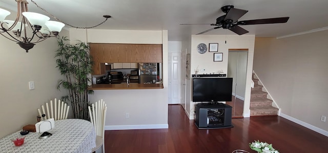 interior space featuring dark hardwood / wood-style flooring, ceiling fan with notable chandelier, and ornamental molding