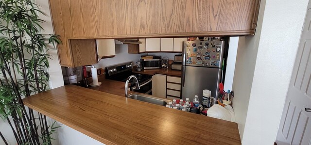 kitchen featuring appliances with stainless steel finishes, wall chimney exhaust hood, and sink