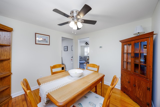 dining space with ceiling fan and light hardwood / wood-style flooring