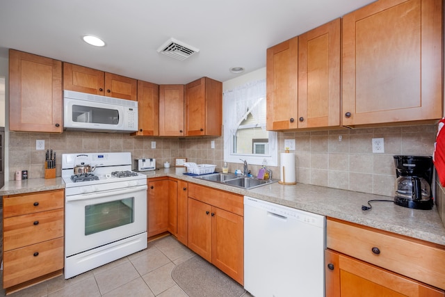 kitchen featuring light tile patterned floors, white appliances, tasteful backsplash, and sink