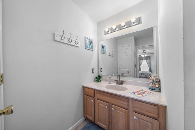 bathroom featuring connected bathroom, baseboards, ceiling fan, and vanity