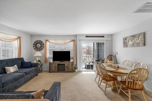 carpeted living room with baseboards and visible vents