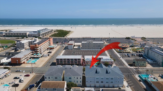 drone / aerial view featuring a water view and a view of the beach