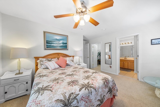 bedroom with a spacious closet, connected bathroom, baseboards, a ceiling fan, and a sink