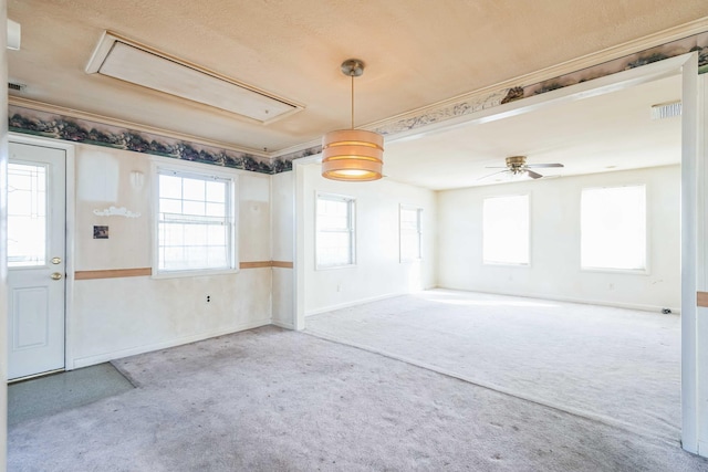 empty room featuring a healthy amount of sunlight, carpet floors, ceiling fan, and ornamental molding