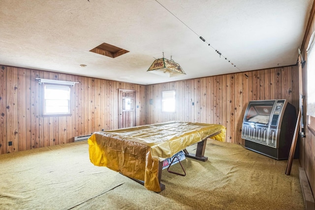 game room with carpet, pool table, a textured ceiling, and wood walls