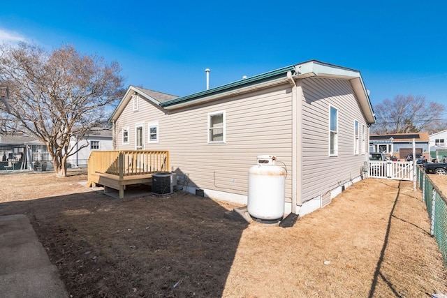 rear view of house with a yard, a deck, and central air condition unit