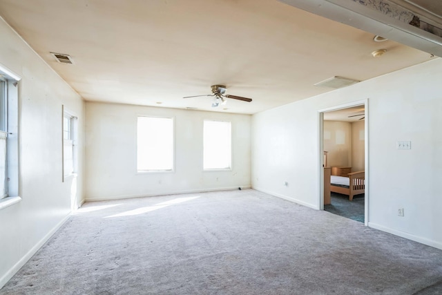 carpeted spare room featuring ceiling fan